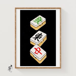 May include: A framed vertical art print featuring three stacked mahjong tiles against a solid black background. The top tile displays a green character, the middle tile shows a black character, and the bottom tile features a red character.