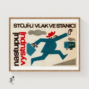 May include: Vintage poster print in a wooden frame. The illustration depicts a running figure in a blue suit and red hat, carrying a briefcase, chasing a train. Text in the image reads "STOJÍ-LI VLAK VE STANICI" and "nastupuj vystupuj".