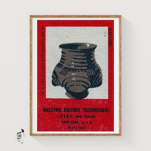 Puede incluir: Una impresión rectangular con una ilustración marrón oscuro de un recipiente de cerámica prehistórico centrado sobre un fondo gris claro, enmarcado por un borde rojo intenso. El texto negro dice NACZYNIE KULTURY TRZCINIECKIEJ, LUBNA, pow. Sieradz, 1450-1200 p.n.e.