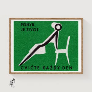 May include: A framed print with a green background and white text that reads "POHYB JE ŽIVOT" and "CVIČTE KAŽDÝ DEN". The print features a black and white illustration of a person exercising with a chair.