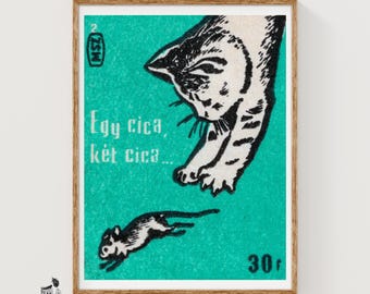 May include: A rectangular print featuring a teal background with a black and white illustration of a cat reaching towards a small mouse. The text reads "Egy cica, két cica..." with "MSZ" in a small oval and the number "30" in the bottom right corner.
