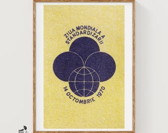 May include: A framed poster with a textured yellow background featuring a dark blue graphic of three overlapping circles above a globe icon. The text reads ZIUA MONDIALA A STANDARDIZARII and 14 OCTOMBRIE 1970 in a circular arrangement around the central design.