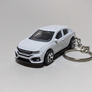 May include: White Honda Civic hatchback keychain. The car is a miniature replica of the real car and has a silver key ring.