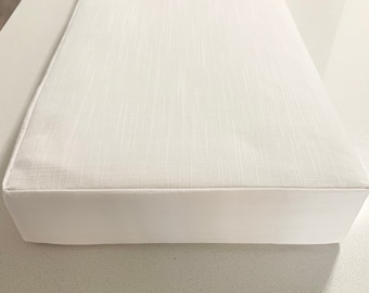 May include: White rectangular bench cushion with a textured fabric top and a solid white bottom.