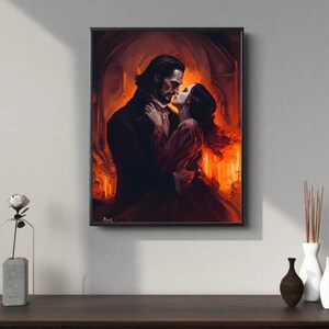Puede incluir: Una obra de arte enmarcada representa una escena rom&aacute;ntica de un hombre y una mujer abraz&aacute;ndose. El hombre lleva un abrigo oscuro y la mujer un vestido rojo. El fondo es un interior c&aacute;lido y anaranjado, creando una atm&oacute;sfera dram&aacute;tica e &iacute;ntima.
