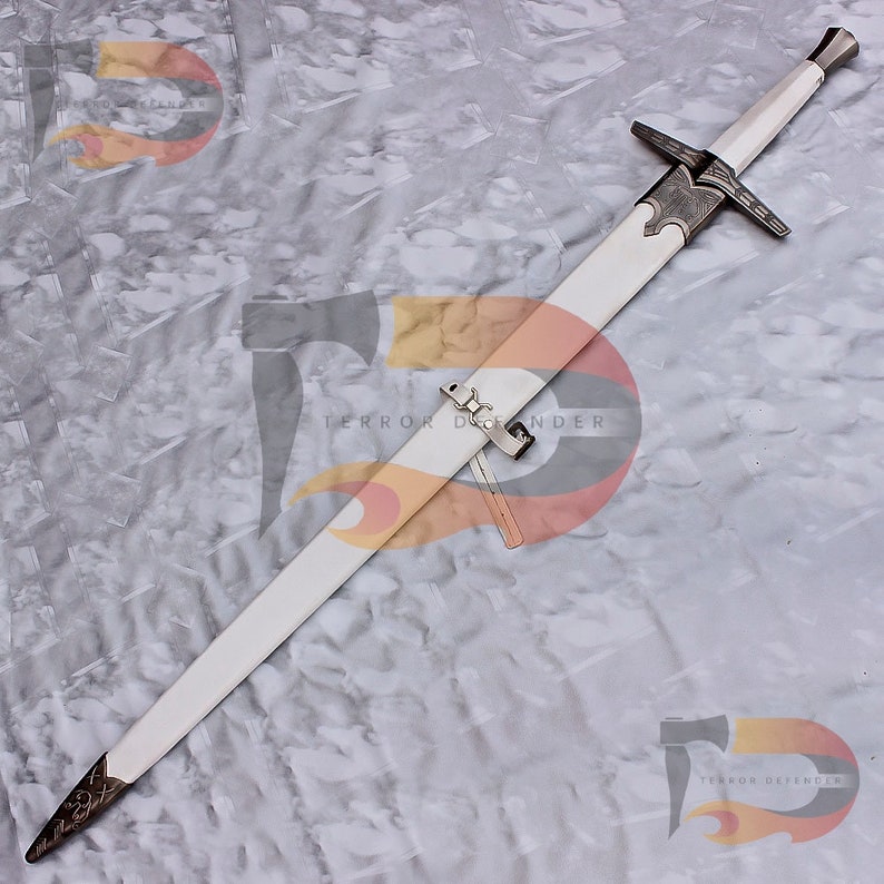 May include: A white sword with a silver hilt and a silver scabbard. The sword has a decorative design on the hilt and scabbard. The sword is lying on a white surface. The text "Terror Defender" is visible in the image.