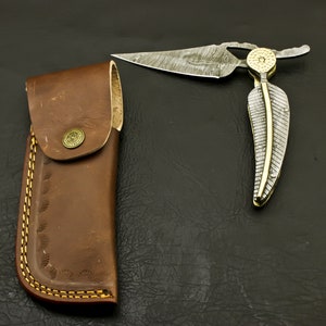 Navaja plegable de acero de Damasco, hecha a mano, con funda de cuero.