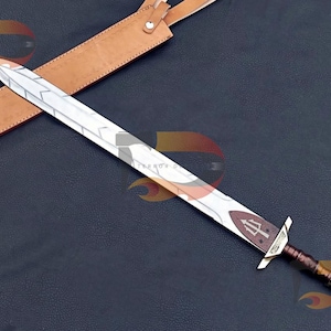 Op de afbeelding: Een zilveren zwaard met een bruine leren schede. Het zwaard heeft een decoratief handvat met een drietandontwerp en een zilveren lemmet met een patroon.