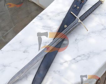 May include: A long, silver sword with a black leather handle and a gold pommel. The sword is in a black leather scabbard with a gold accent.