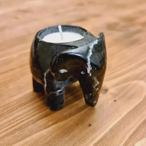 May include: Black marble elephant candle holder with a white candle inside.