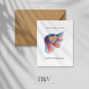May include: A Father's Day card with a watercolor design of a superhero cape in blue, red, and white, with the word "DAD" in the center. The card is accompanied by a brown envelope. Text on the card reads "THANKS FOR BEING MY HERO" and "HAPPY FATHER'S DAY."