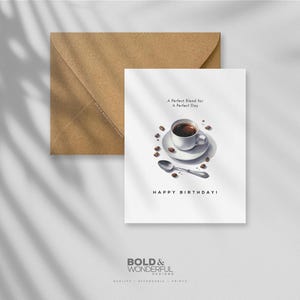 Peut inclure: Carte de vœux blanche avec une illustration d'une tasse de café, des grains de café et une cuillère. La carte porte l'inscription "A Perfect Blend for A Perfect Day" et "HAPPY BIRTHDAY!". Une enveloppe marron est derrière la carte.