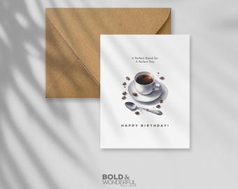 May include: A white greeting card with a coffee cup illustration, coffee beans, and a spoon. The card reads "A Perfect Blend for A Perfect Day" and "HAPPY BIRTHDAY!". A brown envelope is behind the card.