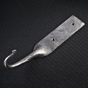 Puede incluir: Un gancho de metal forjado a mano de color plateado. El gancho tiene una placa de montaje rectangular con dos agujeros para tornillos y un gancho curvado. El metal tiene un aspecto texturizado y martillado, lo que sugiere un estilo rústico o industrial.