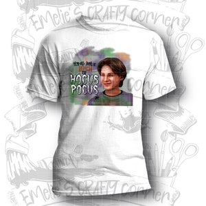 K&ouml;nnte beinhalten: Wei&szlig;es T-Shirt mit einer bunten Grafik eines jungen Mannes mit dem Text "It's all just a bunch of Hocus Pocus".