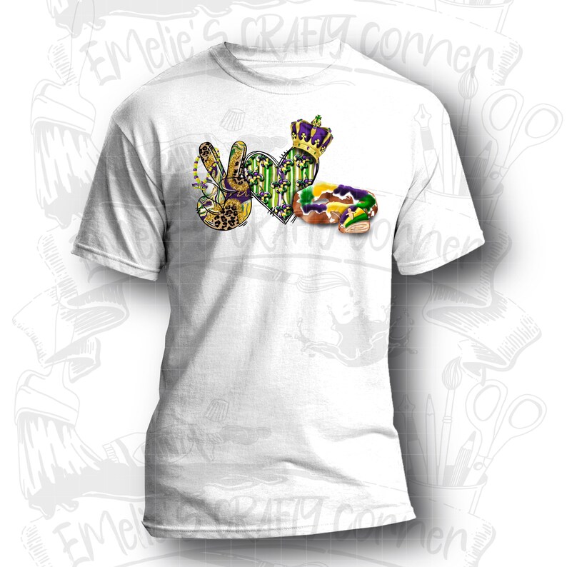 May include: White t-shirt with a purple, green, and gold peace sign, heart, and king cake design. The design includes the words "I Love Mardi Gras".