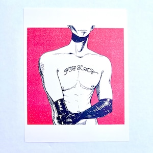 May include: Illustration of a person with the word "FREAK" tattooed on their chest. The person is wearing black gloves and is set against a pink background. The artwork is a print.