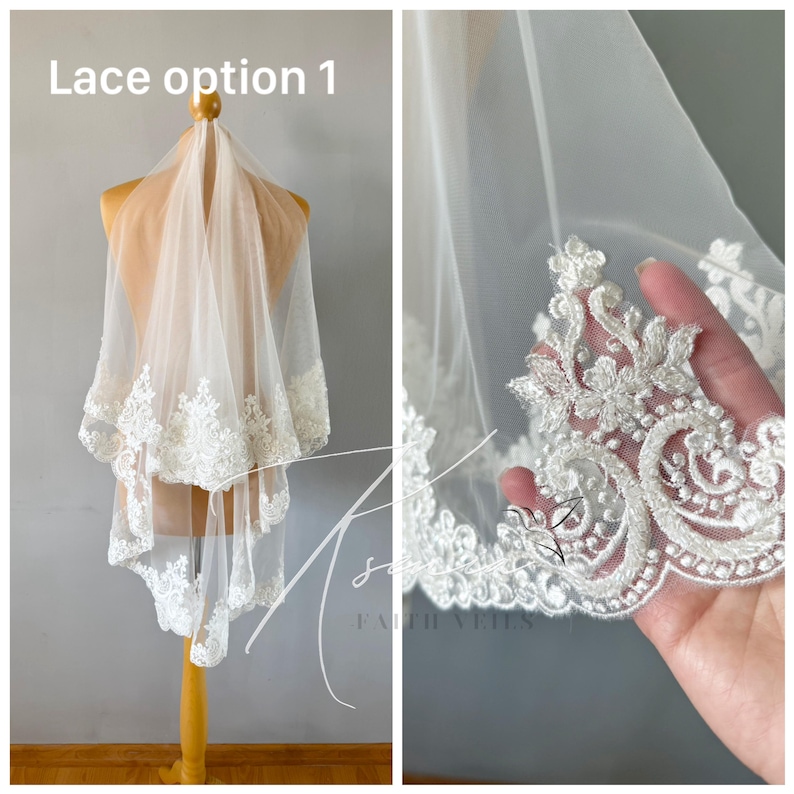May include: A white bridal veil with intricate lace detailing along the edges. The veil is displayed on a mannequin, showcasing the delicate floral and scrollwork patterns of the lace. The text "Lace option 1" is visible.
