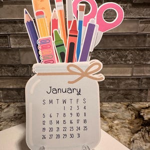 Tischkalender für Lehrer. Lehrer Geschenk. Kalender 2025. Bunte Schulsachen im Glas mit 12 einzelnen Seiten. Staffelei.