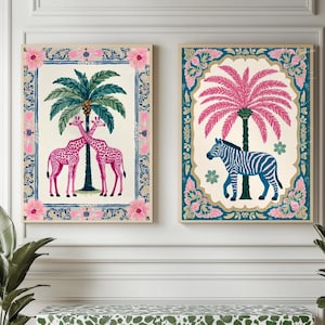 May include: Two framed art prints with animal and palm tree designs. One shows two pink giraffes beneath a green palm tree. The other depicts a blue and white zebra under a pink palm tree. Both prints have decorative borders.
