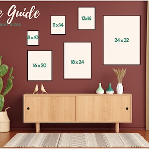 May include: A size guide for print sizes is displayed on a maroon wall. The guide shows framed prints in various sizes, including 8x10, 11x14, 12x16, 16x20, 18x24, and 24x32 inches. A cactus in a woven basket and a wooden cabinet with decor are also visible.