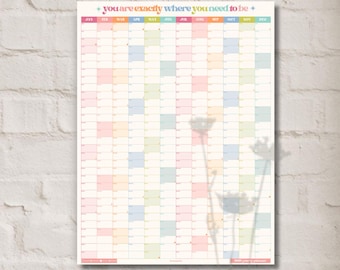 May include: A large wall calendar with a grid of squares in pastel colors. The calendar has the text "you are exactly where you need to be" at the top. The months of the year are listed across the top.