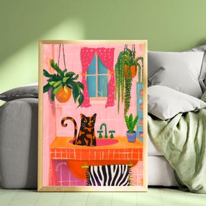 May include: A framed art print depicts a cat in a bathroom scene. The cat is orange and black, sitting in an orange sink. Pink walls, a window with pink curtains, and hanging plants complete the whimsical illustration.