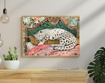 May include: A framed art print depicts a sleeping snow leopard on a bed with a floral patterned pink blanket and pillow. The headboard is ornate with a green and gold design. The background features a floral wallpaper.