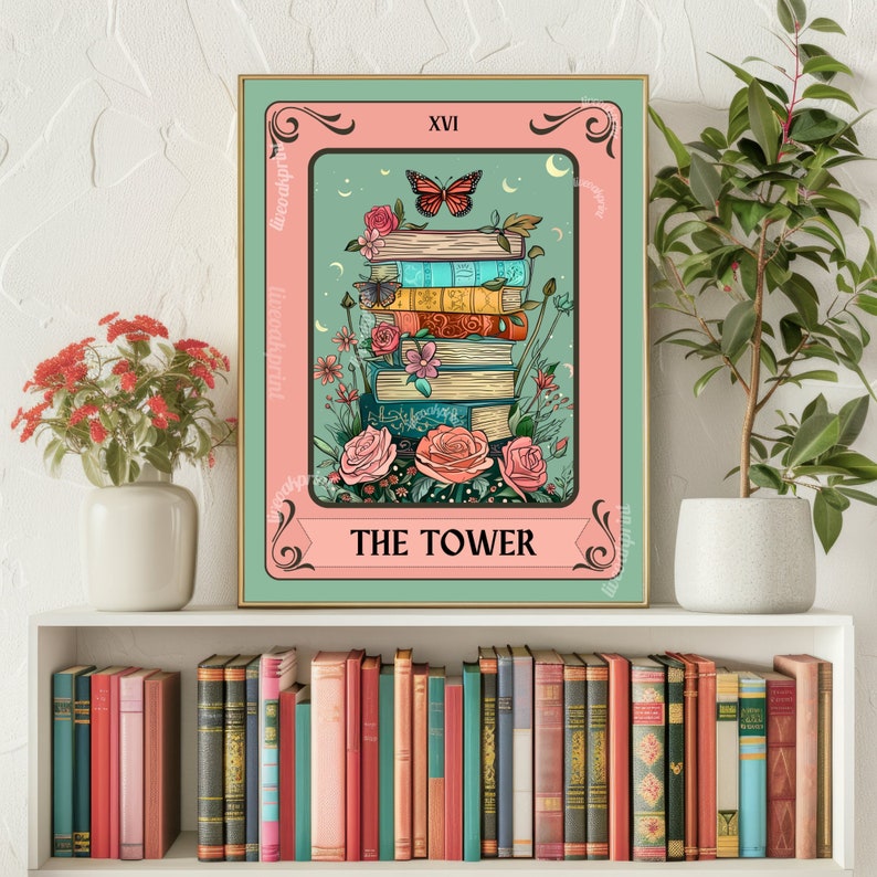 May include: A framed tarot card print featuring a stack of books with flowers and butterflies. The card is framed in a pink and green border with the text "THE TOWER" at the bottom and "XVI" at the top. The background is a light teal color.