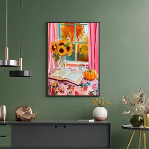 Op de afbeelding: Een schilderij van een raam met uitzicht op herfstbladeren, een boek, een kopje thee, een pompoen en zonnebloemen in een vaas op een bloemenkleed.