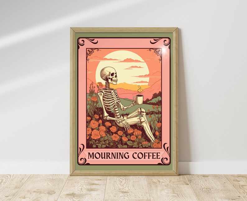 May include: Framed art print featuring a skeleton relaxing in a field of orange roses, holding a coffee cup. The background shows a sunset and mountains. The text "MOURNING COFFEE" is at the bottom of the print. The frame is a light green color.