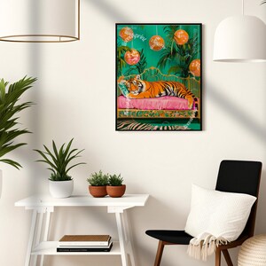 May include: A tiger is lying on a pink and gold chaise longue with a green background. The tiger is surrounded by disco balls and palm trees. The image is framed in black.