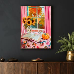 Op de afbeelding: Een schilderij van een stilleven met zonnebloemen, een boek, een kopje thee en een pompoen op een tafel met een bloemenkleed. Het raam achter de tafel toont een uitzicht op herfstbladeren.
