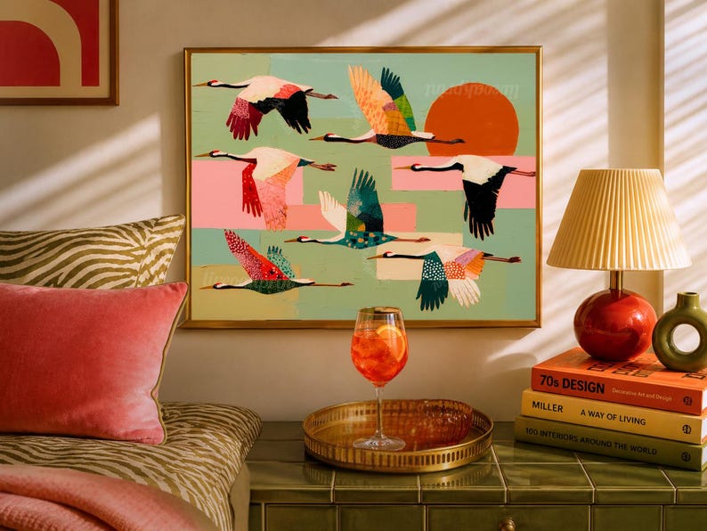 May include: A framed wall art print featuring a flock of stylized cranes in flight against a light green background with a large orange sun, pink rectangular accents, and various colorful patterns on the birds' wings and bodies.