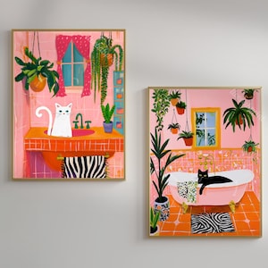 Peut inclure: Deux impressions d'art mural encadrées représentant des scènes de salle de bain avec des chats. L'une montre un chat blanc dans un lavabo orange avec des carreaux roses et des plantes suspendues. L'autre montre un chat noir dans une baignoire rose.