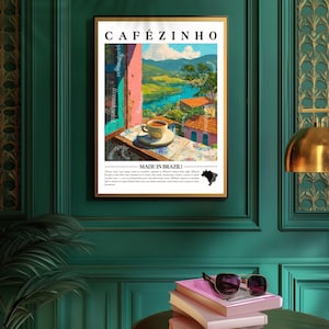 K&ouml;nnte beinhalten: Ein gerahmter Kunstdruck mit dem Text "CAF&Eacute;ZINHO" oben und "MADE IN BRAZIL!" unten. Das Kunstwerk zeigt eine Kaffeetasse auf einer Untertasse vor einer malerischen Aussicht auf einen Fluss und farbenfrohe Geb&auml;ude, mit einem Landschaftshintergrund.