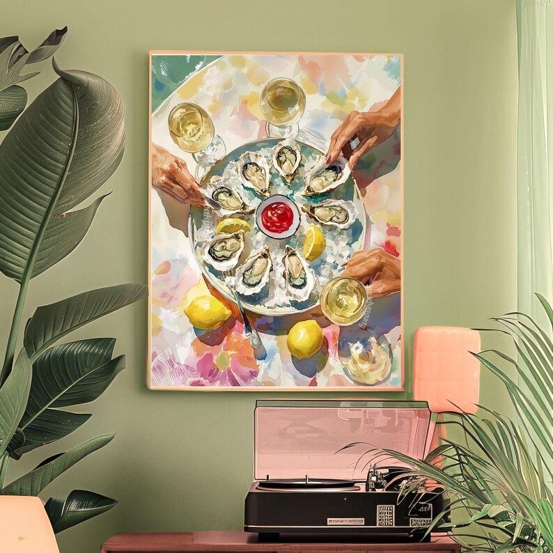 May include: A framed art print showing a plate of oysters, lemon wedges, and a small bowl of red sauce. Several hands reach for the oysters, and glasses of white wine are visible. The background has a floral pattern.