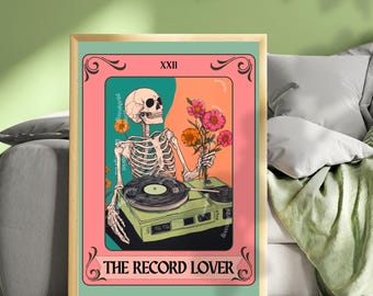 May include: A framed art print featuring a skeleton holding flowers and standing next to a record player. The artwork has a pink, orange, and teal color scheme with the text "THE RECORD LOVER" at the bottom.