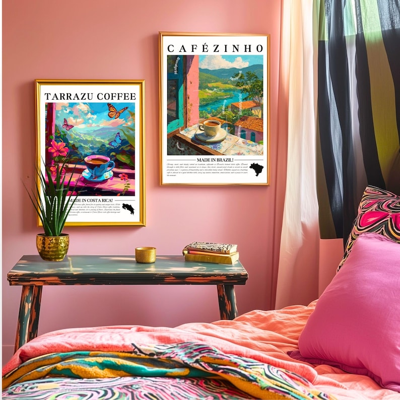 K&ouml;nnte beinhalten: Zwei gerahmte Kunstdrucke mit goldenen Rahmen h&auml;ngen an einer rosa Wand. Ein Druck zeigt "Tarrazu Coffee" und zeigt eine Kaffeetasse mit Schmetterlingen. Der andere zeigt "Caf&eacute;zinho" und zeigt eine Kaffeetasse mit Landschaftsansicht.
