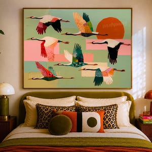 May include: A rectangular wall art print featuring six stylized cranes in flight against a sage green background. The birds display colorful, patterned wings in shades of red, orange, blue, and black. A large, solid orange circle represents the sun.