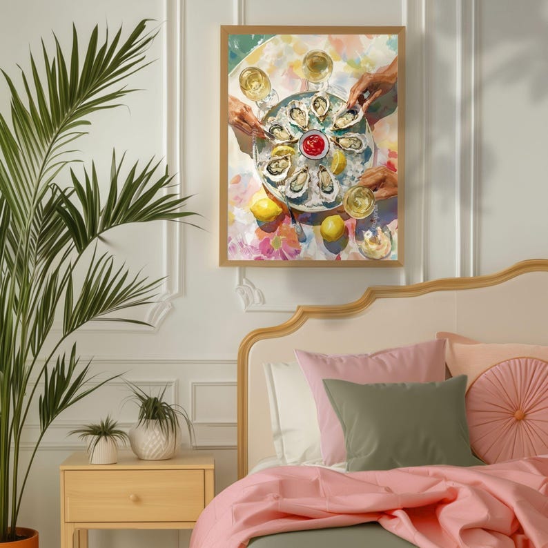 May include: A framed art print showing a platter of oysters with lemons, hands, and wine glasses. The artwork is set on a colourful floral tablecloth. The print hangs above a bed with pink and green bedding.