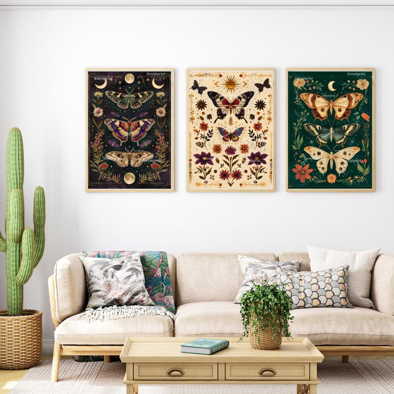 Op de afbeelding: Drie ingelijste prints met een donkere, een lichte en een groene achtergrond. Elke print toont een ander vlinderontwerp met bloemmotieven en hemelse elementen zoals manen en sterren.