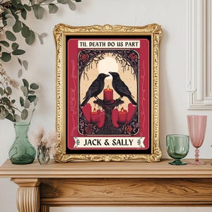 May include: Framed art print with a gold frame. The artwork features two black crows facing each other above a candlelit altar. The text "TIL DEATH DO US PART" and "JACK & SALLY" are displayed on the print. The background is burgundy with rose accents.