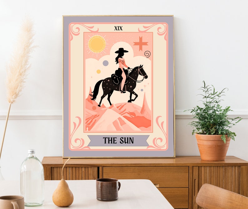 May include: A tarot card illustration depicting a woman riding a horse in a desert landscape. The card is titled "The Sun" and is numbered XIX. The illustration is in a vintage style with a pink and orange colour scheme.