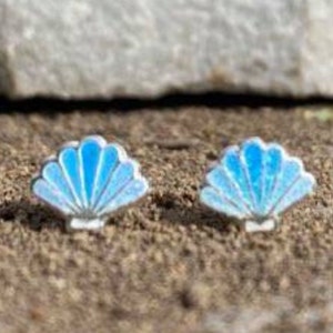 May include: A pair of silver stud earrings featuring a blue iridescent seashell design.