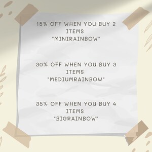May include: A white piece of paper with tape on the top and bottom corners. The paper has text that reads "15% OFF WHEN YOU BUY 2 ITEMS "MINIRAINBOW"" 30% OFF WHEN YOU BUY 3 ITEMS "MEDIUMRAINBOW" 35% OFF WHEN YOU BUY 4 ITEMS "BIGRAINBOW"