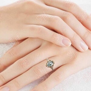 May include: A gold ring with a large, clear, faceted gemstone set in a floral design.