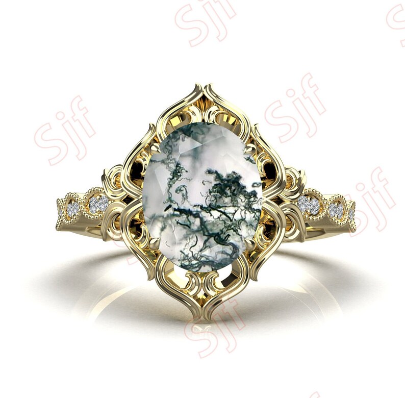 May include: A gold ring with a large oval-shaped moss agate gemstone set in a filigree design. The ring band is accented with small diamonds.