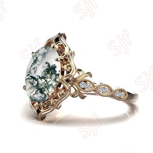 May include: A gold ring with a large oval-shaped green and white agate gemstone set in a delicate filigree design. The band is accented with small diamonds.
