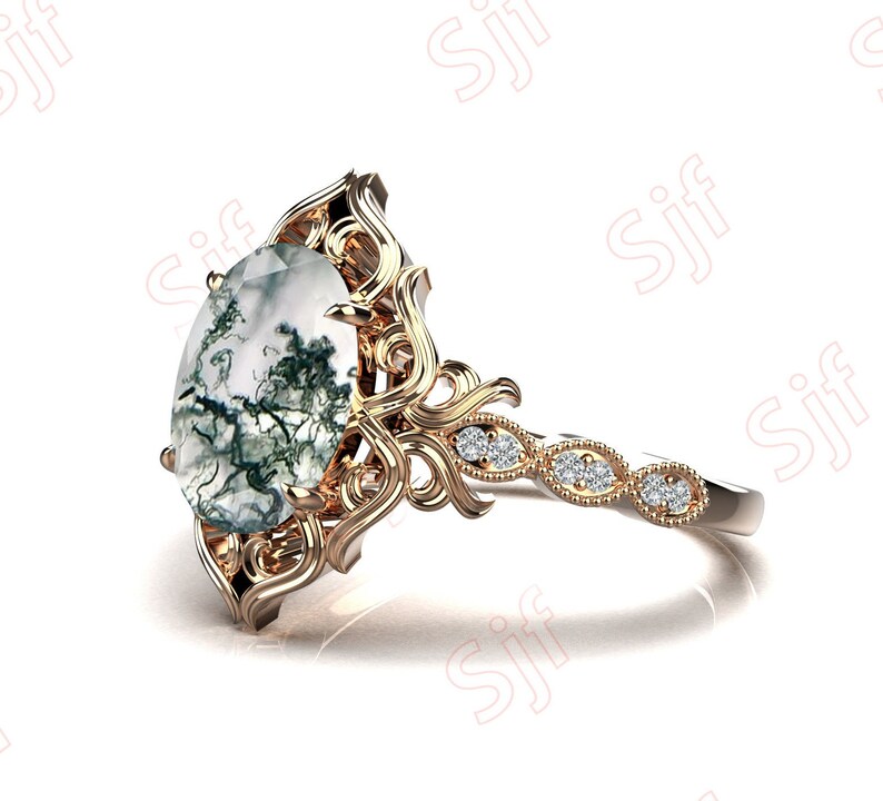 May include: A gold ring with a large oval-shaped green and white agate gemstone set in a delicate filigree design. The band is accented with small diamonds.
